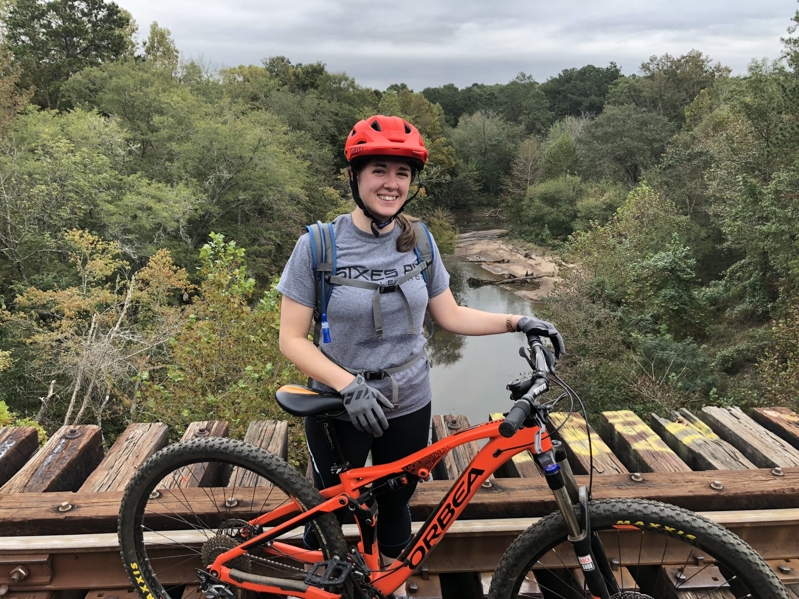 Person mountain biking on wooden bridge in forest
