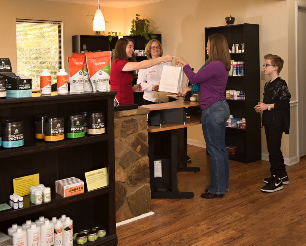 People shopping at a nutrition store counter.